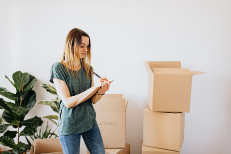 A woman making notes next to boxes